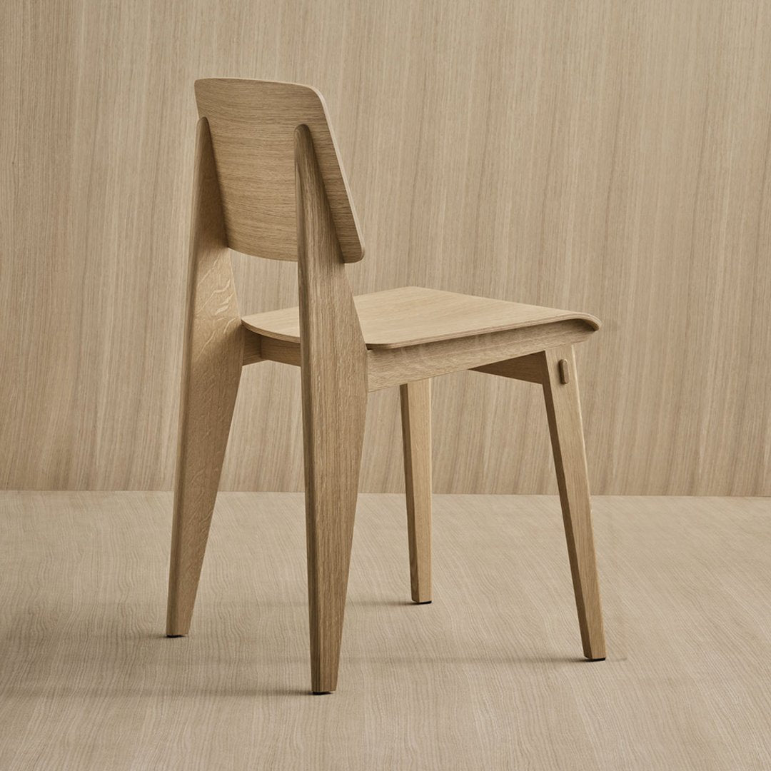 Natural light wood chair with a smooth finish and minimalist design against a soft beige background.