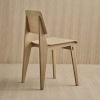 Natural light wood chair with a smooth finish and minimalist design against a soft beige background.