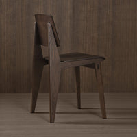 Rustic dark wood chair with angular design, featuring smooth, rich brown tones and sleek lines against a wooden backdrop.