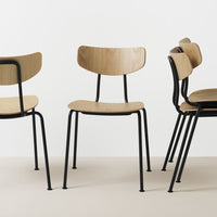 Natural wood finish chairs with black metal legs, featuring minimalist design and a modern aesthetic.