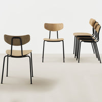 Five sleek wooden chairs with light oak seats and black metal frames against a minimalist white background.