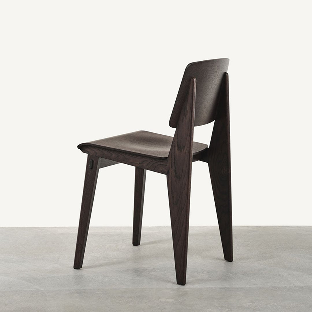 Dark wood chair with a minimalist design, featuring clean lines and a smooth finish against a light background.