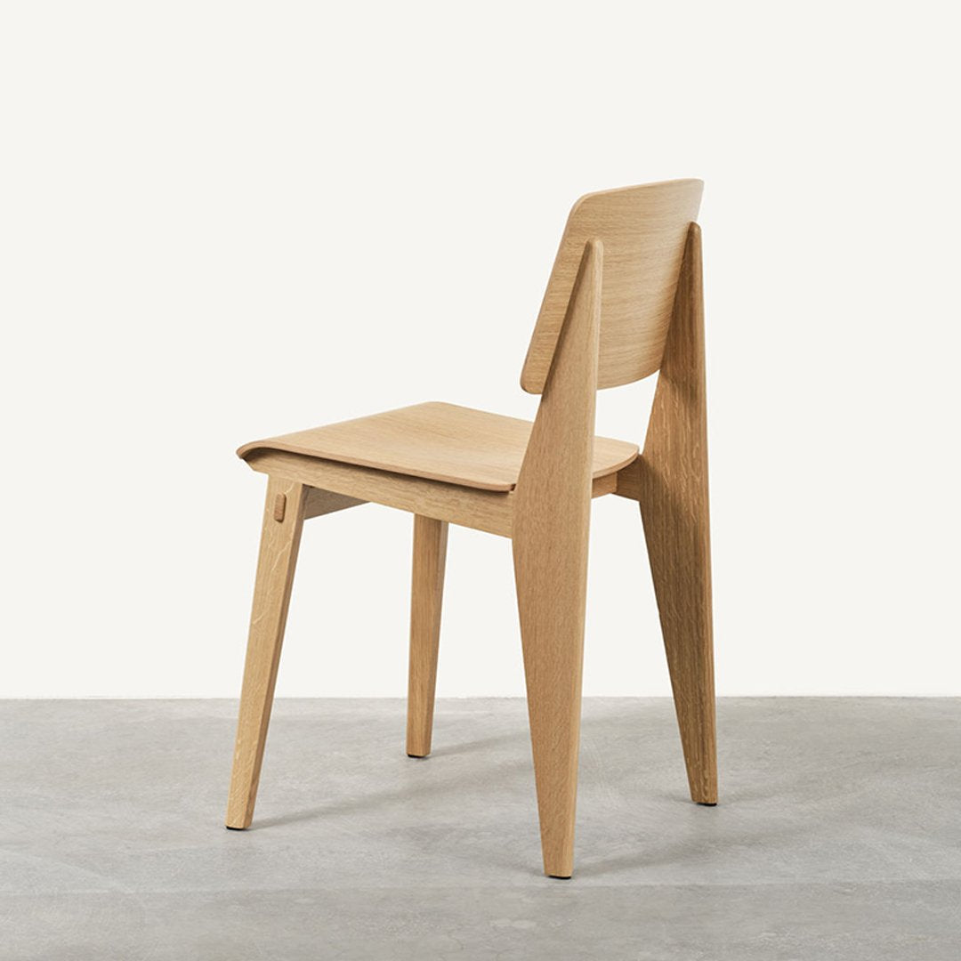 Natural wood chair with a light oak finish and minimalist design, featuring clean lines and a smooth texture.