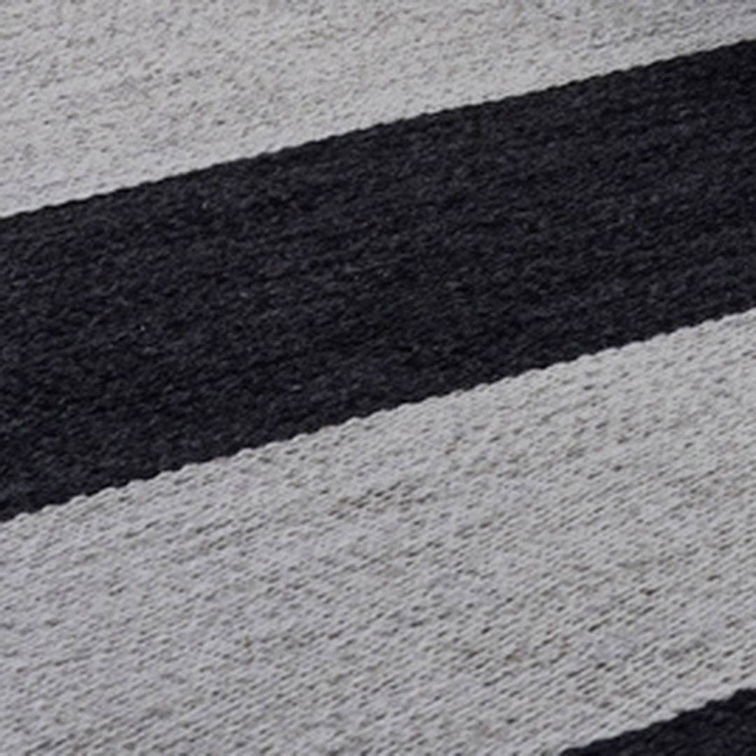 Black and gray striped pattern on a soft woven rug, creating a modern and stylish decor accent.