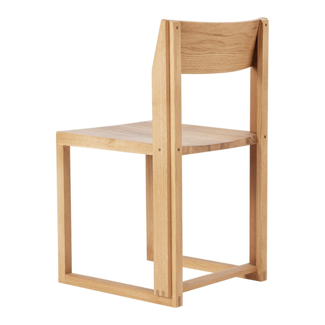 Light wood chair with a minimalist design featuring natural grain patterns and a simple, modern silhouette.