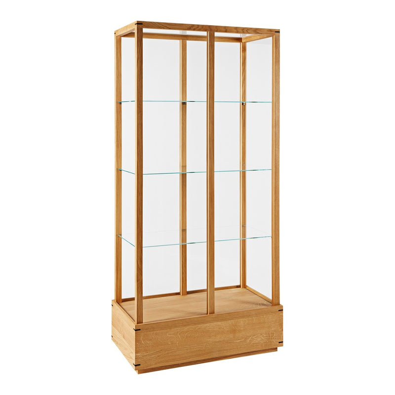 Natural wood display cabinet with clear glass shelves, showcasing a minimalist design in light oak tones.