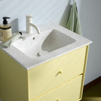 Yellow bathroom vanity with a speckled white countertop and soft green accents, featuring minimalist design elements.