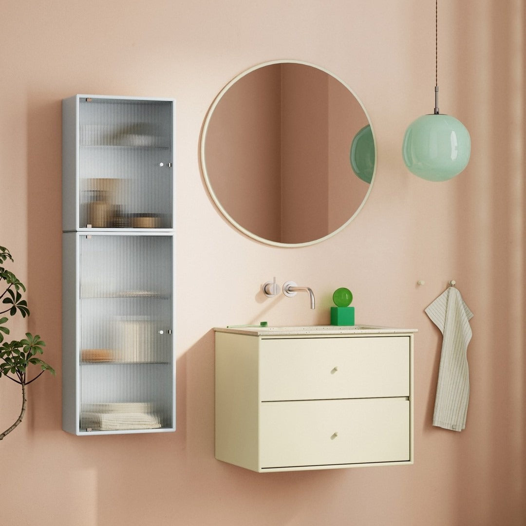 "Modern bathroom in soft peach tones with a mint green pendant light and sleek white cabinetry."