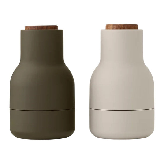 "Two modern bottles: one in olive green, the other in soft white, with natural wood lids and smooth matte finishes."