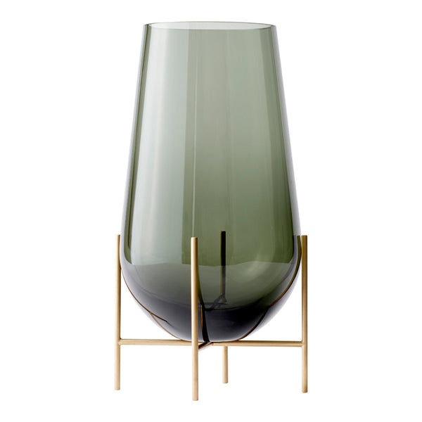 Green tinted glass vase with a smooth gradient, resting on a sleek gold metal stand.