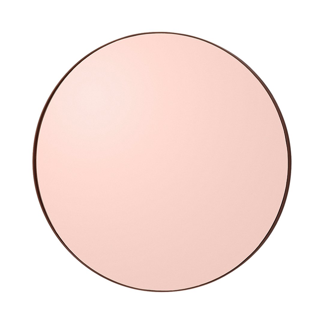 Round mirror with a soft pink surface and a sleek dark frame, adding elegance to any decor.
