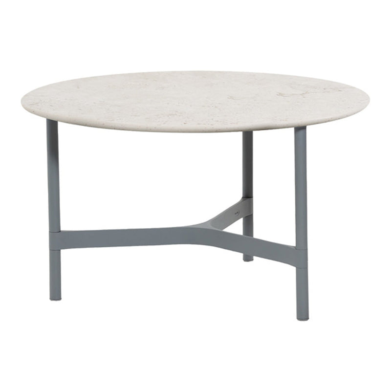 Round coffee table with a smooth, light beige top and a sleek gray metal base.