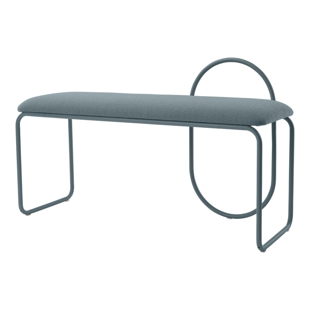 Modern upholstered bench in soft grey fabric with sleek, curved metal legs and circular accent detail.