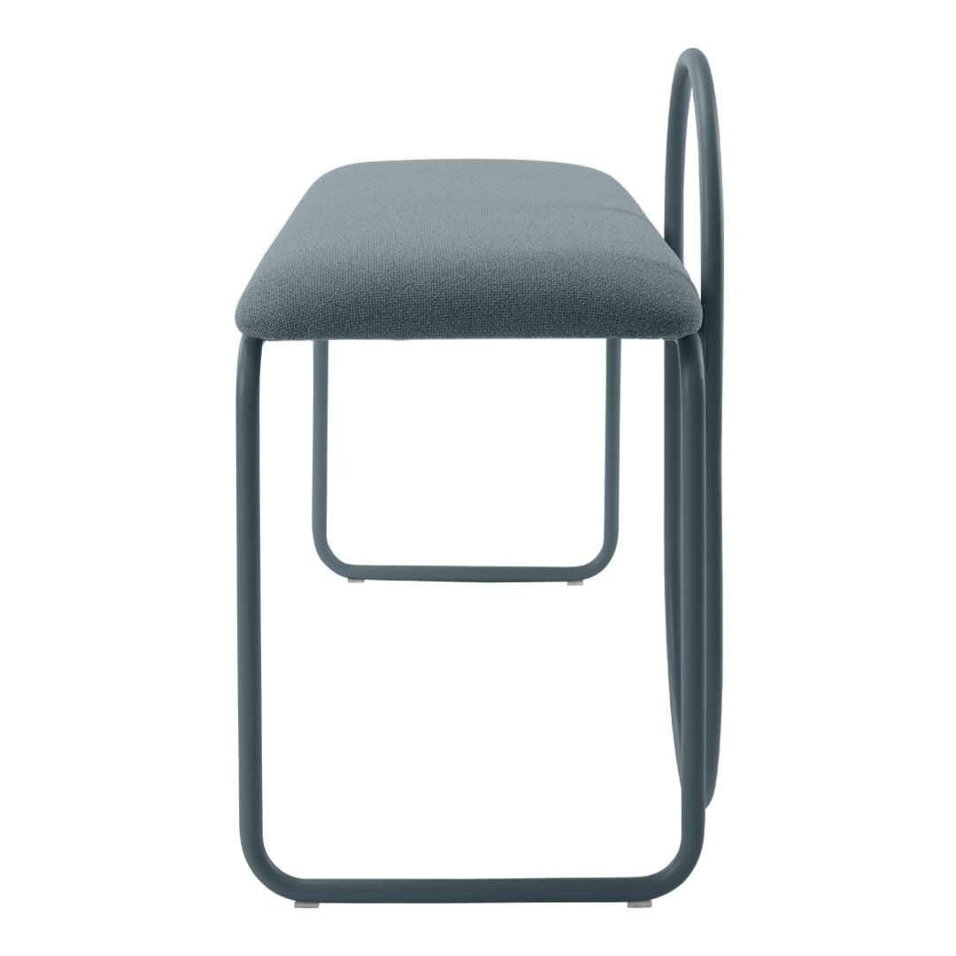 Side view of a modern bench with a soft gray upholstery and sleek metal frame in a complimentary dark hue.