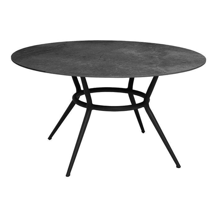 Round black table with a smooth surface and bold, minimalist metal legs in a sleek design. Perfect for modern decor.