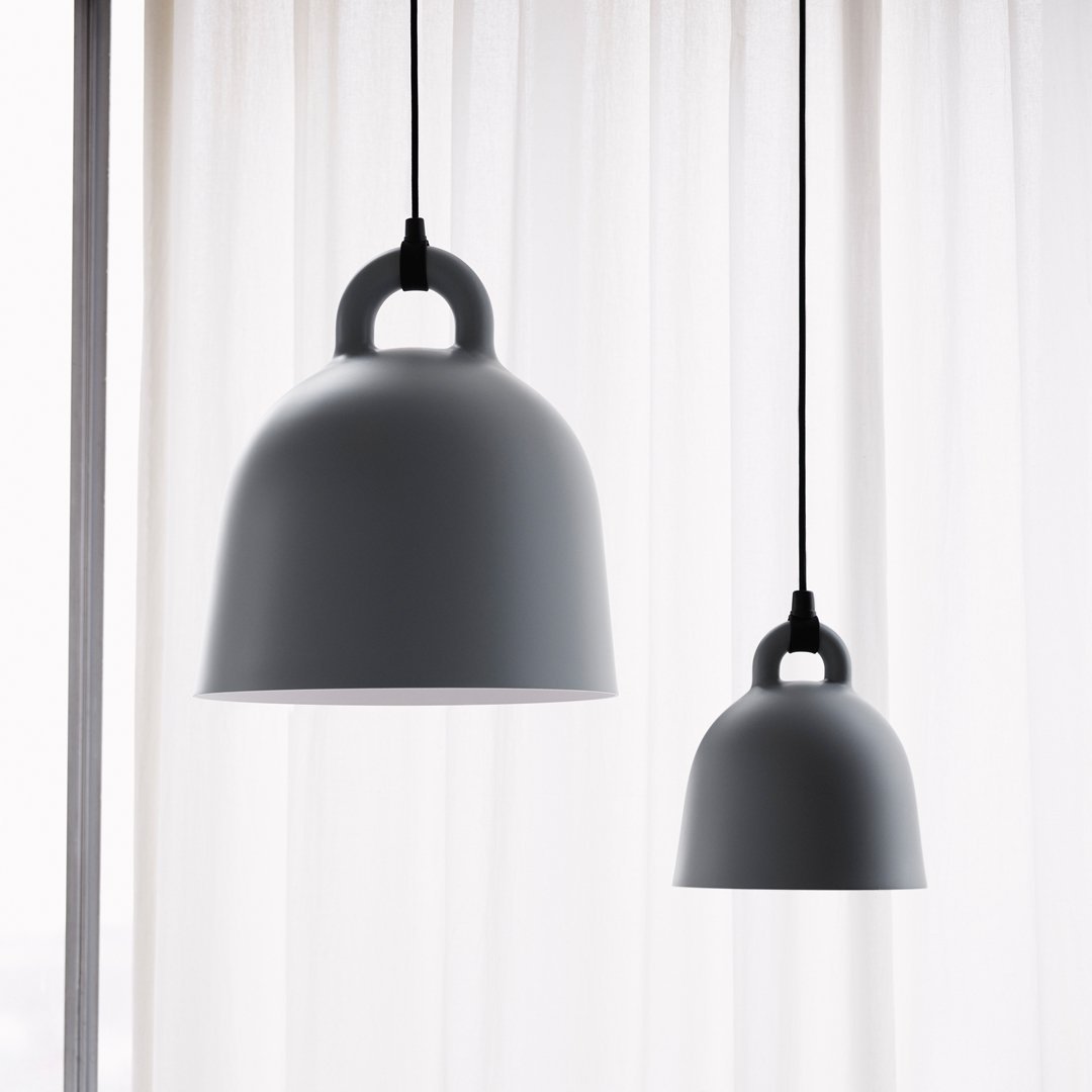 Gray pendant lamps with smooth finishes, hanging against a soft, sheer white curtain background.