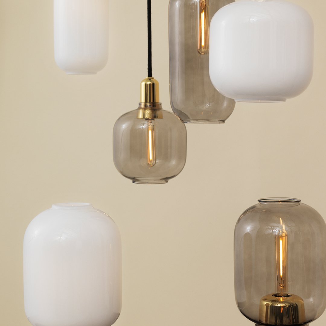 Chic pendant lights featuring clear and matte white glass, with a sleek gray finish and warm brass accents.