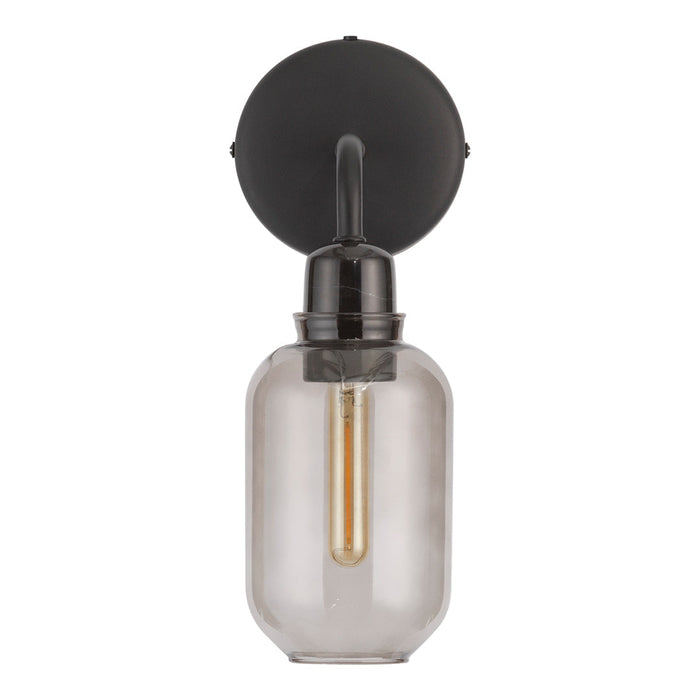Black wall-mounted light fixture with a clear glass shade and warm gold bulb. Modern, minimalist design.