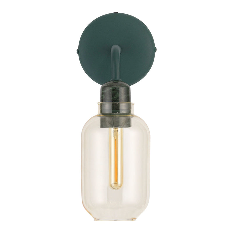 Green wall mount light fixture with a round base, clear glass shade, and a warm yellow filament bulb.