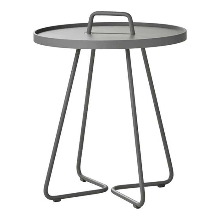 Gray metal side table with a round top and modern, minimalist design, featuring sleek curved legs.