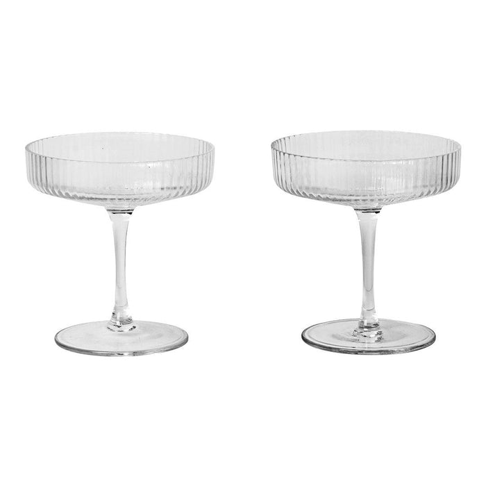 Clear glass coupe glasses with elegant ribbed and smooth designs, perfect for cocktails and dessert.