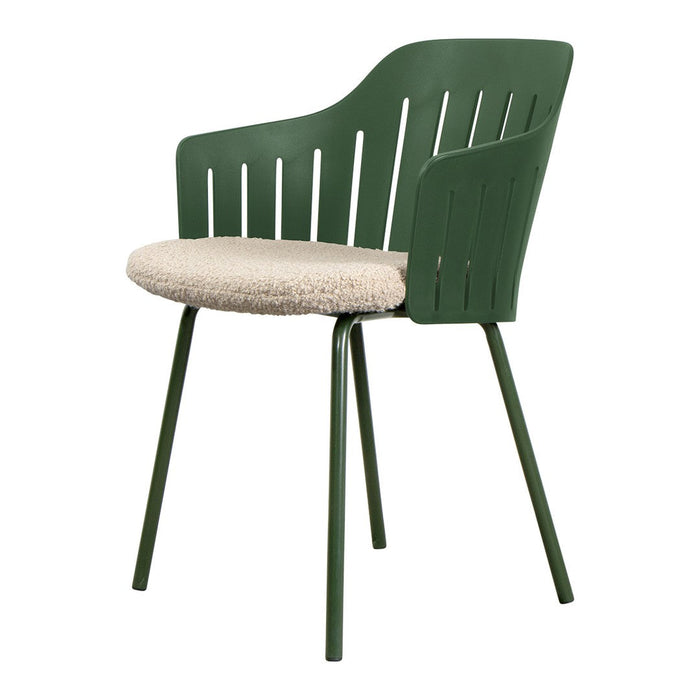 Green plastic chair with a textured beige cushion, featuring vertical slats and sleek legs for a modern look.