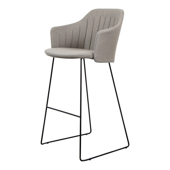 Light gray upholstered bar stool with vertical ridges on a sleek black metal base. Perfect blend of modern colors and textures.