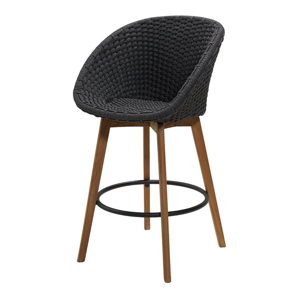 Black woven bar stool with a textured pattern and wooden legs, complemented by a metal footrest.