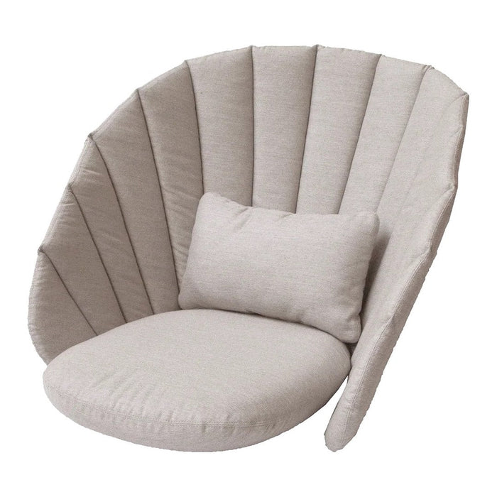 Beige shell-shaped chair with plush seating and vertical stitched pattern, complemented by a matching cushion.