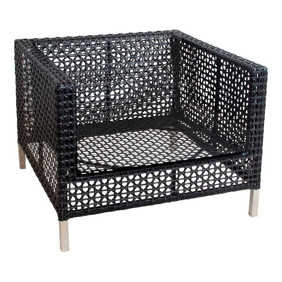 Black wicker armchair with geometric cut-out patterns and silver metal legs.
