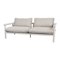 Beige two-seater sofa with soft cushions and a sleek white metal frame, perfect for modern outdoor settings.
