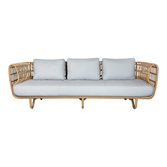 Light blue cushions on a natural rattan sofa with a minimalist design; sleek lines and open weave pattern.