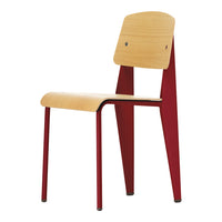 Wooden chair with a natural wood seat and back, contrasting red metal legs and supports, featuring a simple, modern design.