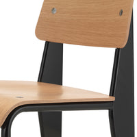 Light wood chair seat with sleek black metal frame and minimalistic design.