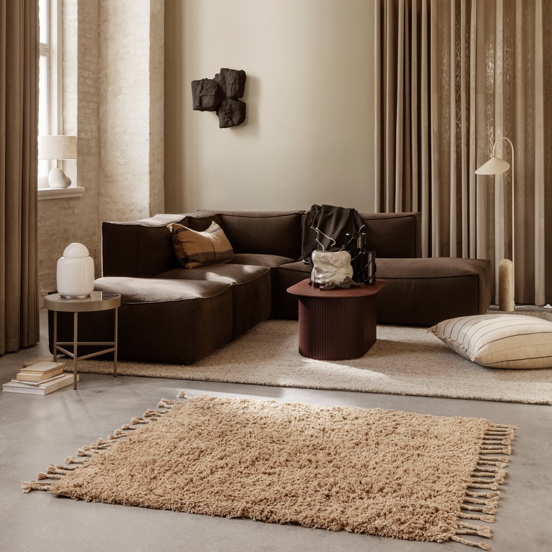 Soft beige shag rug with textured fringe, complementing a warm-toned living room with brown and neutral accents.