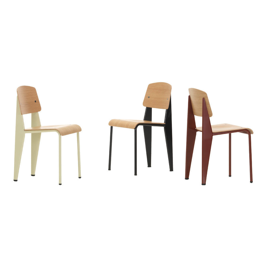 Three stylish chairs featuring a mix of cream, black, and burgundy legs with natural wood seats. Modern design with distinct colors.