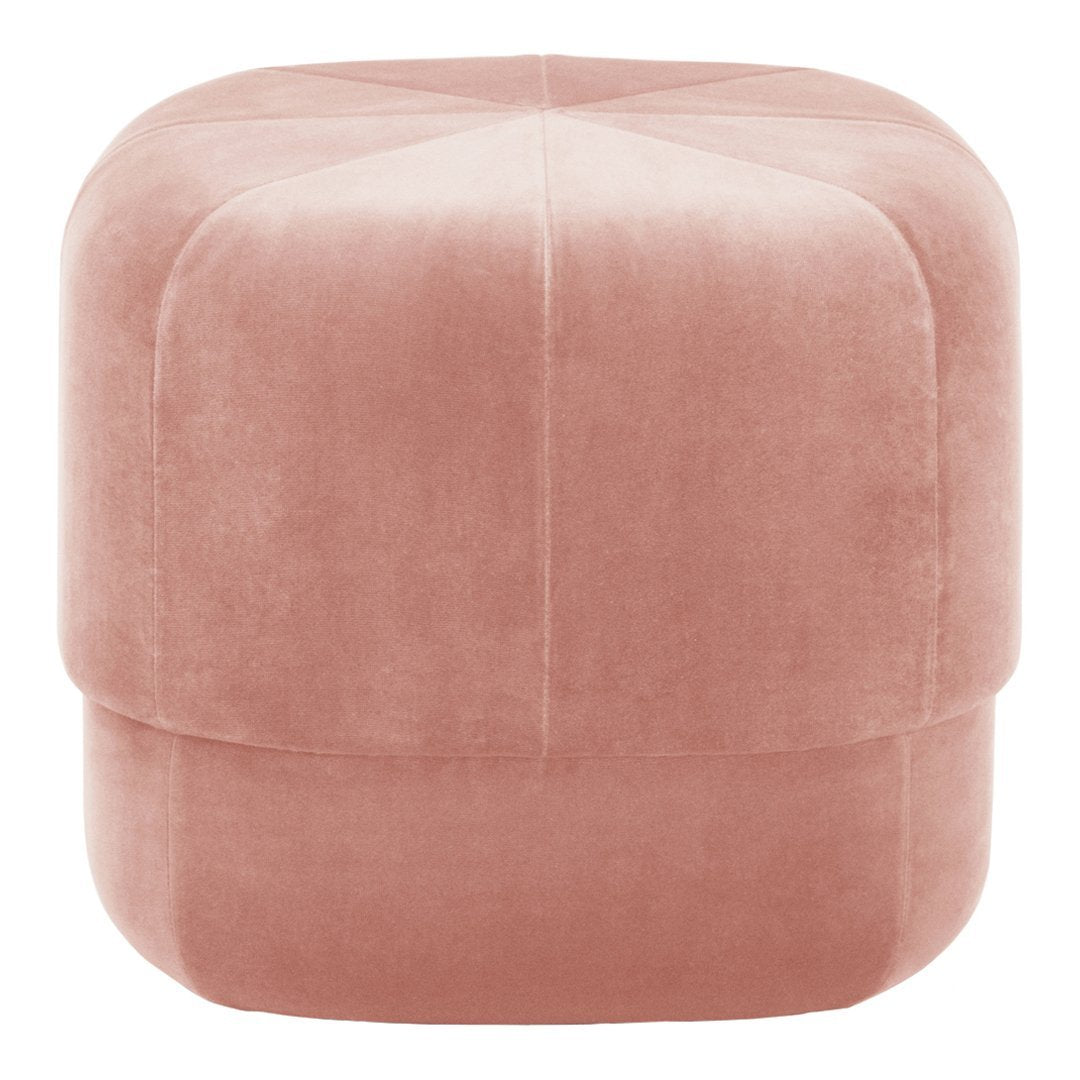 Soft pink velvet pouf with subtle diamond quilting pattern, perfect for modern decor.