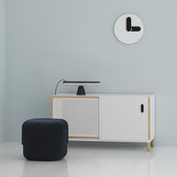 White cabinet with natural wood accents, textured rattan pattern, and a solid navy ottoman in a minimalist setting.