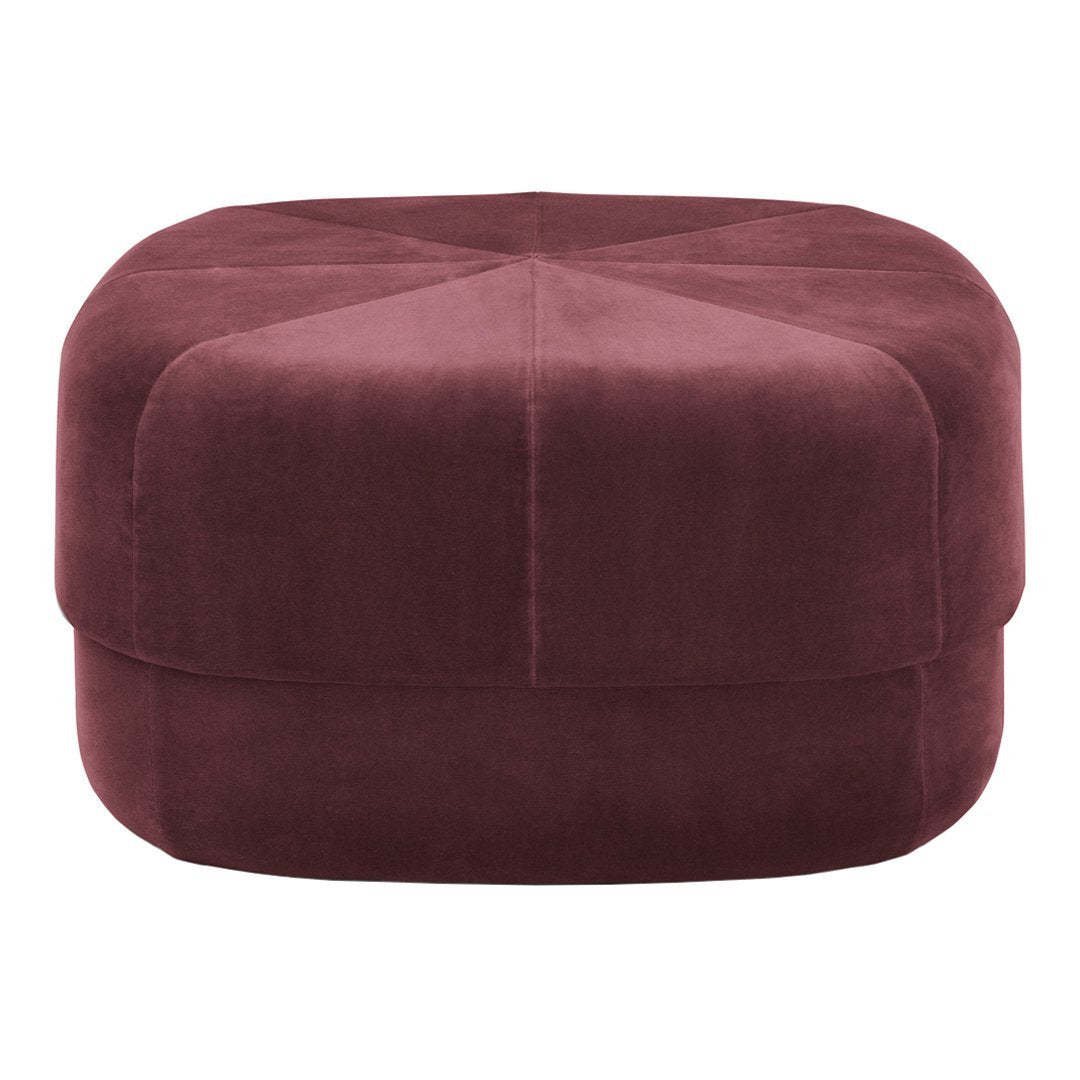 Plush burgundy ottoman with a hexagonal shape and quilted diamond pattern on top. Perfect for any modern decor.
