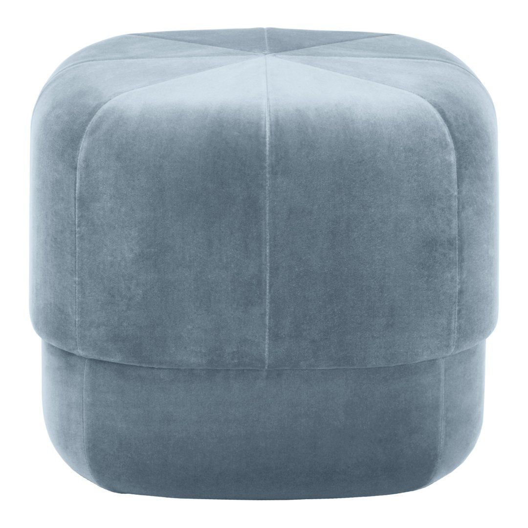 Soft blue velvet pouf with a smooth, textured surface and geometric pattern, perfect for modern decor.