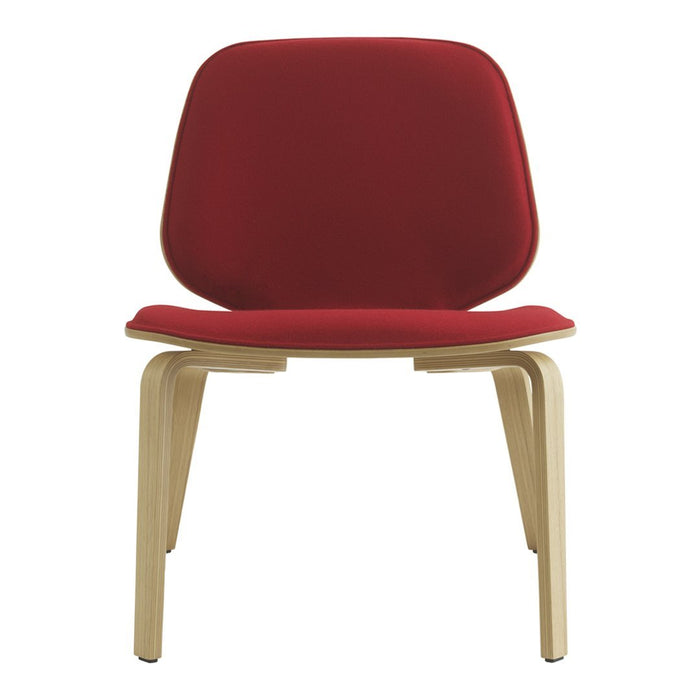 Red upholstered chair with smooth contours and wooden legs, showcasing a minimalist design and vibrant color.