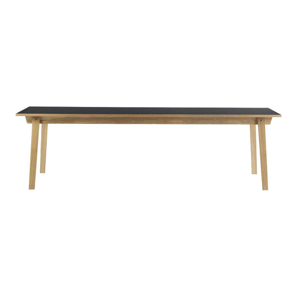 Wooden table with a sleek black top and natural wood legs, showcasing a minimalist design. Ideal for any modern space.