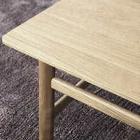 Natural oak wood table with a smooth, light finish, featuring a minimalist design and subtle grain pattern.