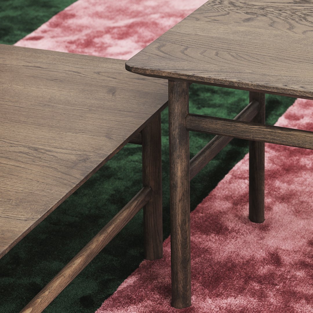 Wooden tables with rich brown finish on a vibrant pink and green patterned rug.