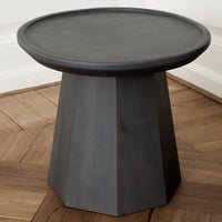 Black geometric side table with a smooth circular top and angular base, featuring a modern minimalist design.