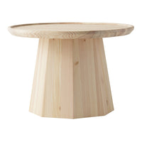 Light beige wooden table with a round top and geometric, faceted base. Natural grain patterns highlight organic textures.