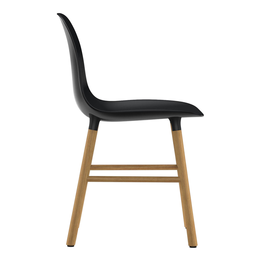 Black molded seat with smooth curves and natural wooden legs. Sleek, modern design perfect for any setting.