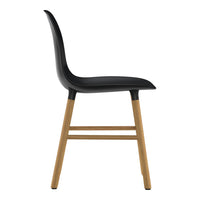Black molded seat with smooth curves and natural wooden legs. Sleek, modern design perfect for any setting.