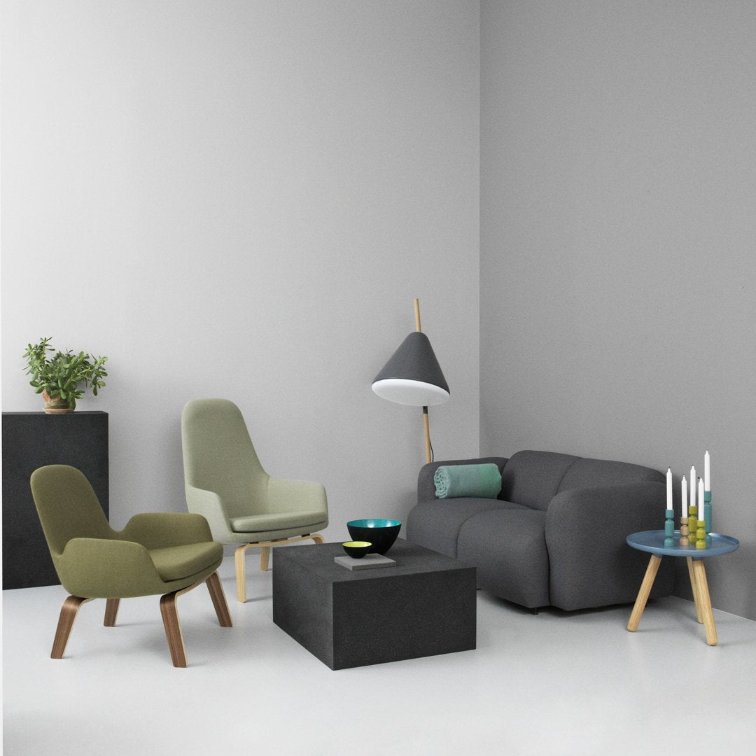Modern living room featuring gray walls, olive green chairs, a dark gray sofa, and a patterned blue coffee table.