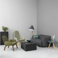 Modern living room featuring gray walls, olive green chairs, a dark gray sofa, and a patterned blue coffee table.
